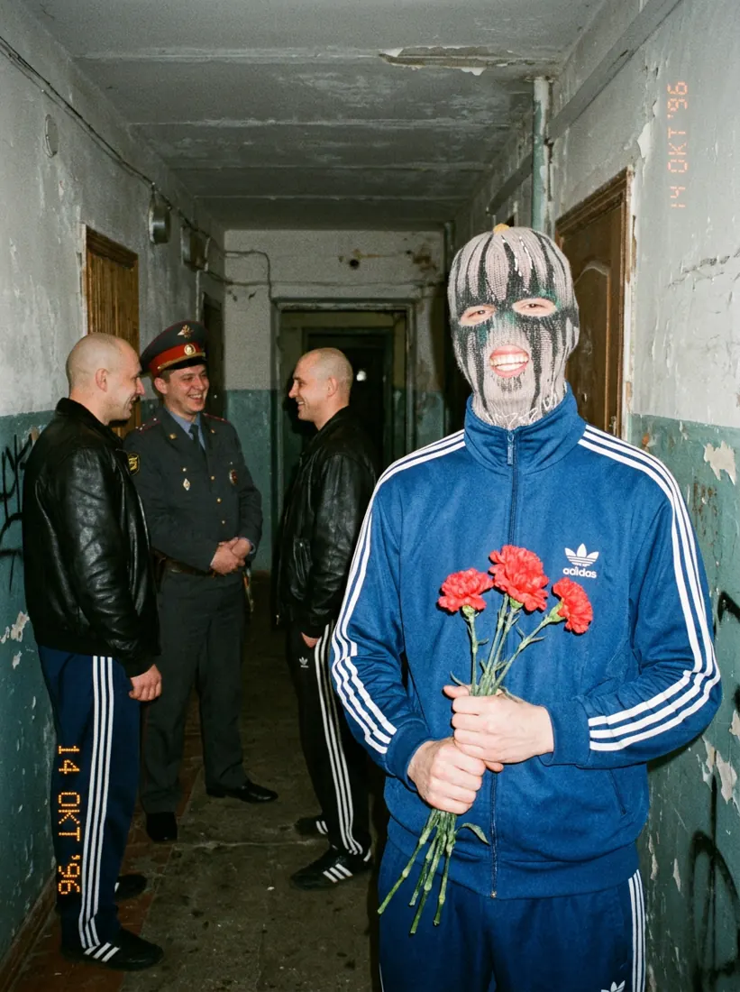 GLAKI with carnations next to policemen in a stairwell